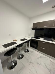 a kitchen with a counter and two bar stools at Appartement meublé proche du futuroscope in Poitiers +2 photos