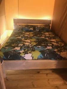 een slaapkamer met een bed met een bloemenpatroon bij Oh! Campings - Camping Paradis A l'ombre des tilleuls in Peyrouse