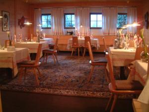 ein Esszimmer mit Tischen, Stühlen und Fenstern in der Unterkunft Hotel Sparerhof in Vilpian