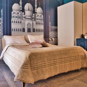 a bedroom with a large bed with a mosque mural on the wall at Kore Luxury Suite e Spa in Naples