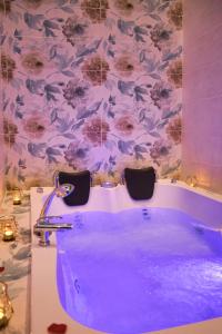 una vasca viola in un bagno con carta da parati floreale di Kore Luxury Suite e Spa a Napoli