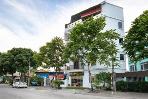 ein weißes Gebäude an der Straßenseite in der Unterkunft Hanoi Airport Suites in Sóc Sơn