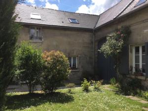 une maison en briques avec un garage et une cour dans l'établissement chez tatie yvette, à Cuise-la-Motte