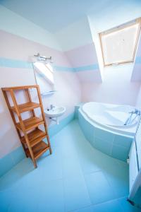 a blue bathroom with a ladder and a tub and sink at Apartmánový Dom River in Blatnica