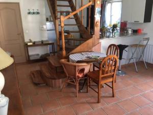una cocina con mesa y sillas y una escalera en chez tatie yvette, en Cuise-la-Motte