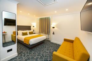 una camera d'albergo con letto e divano di Park Avenue Bayswater Inn Hyde Park a Londra