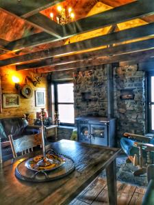 a living room with a wooden table and a fireplace at The Bothy in Newton Stewart