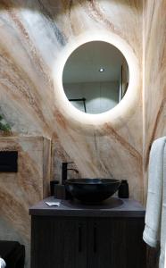 La salle de bains est pourvue d'un lavabo et d'un miroir. dans l'établissement Hotel Rubin***, à Gheorgheni