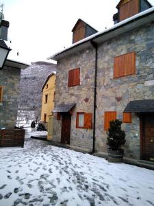 een oud stenen gebouw met sneeuw op de grond bij Adosado gran terraza parking bodega ideal bicis in Villanova