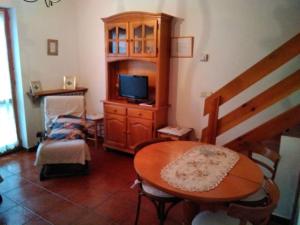 un soggiorno con un tavolo di legno e una televisione di Adosado con gran terraza a Villanova