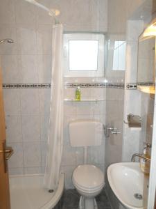 biała łazienka z toaletą i umywalką w obiekcie Apartments & Rooms Tea w mieście Zadar +32 zdjęcia