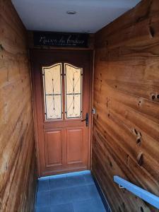 a wooden door in a room with wooden walls at la maison du bonheur in Saint-Germain-Laval