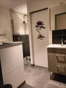 La salle de bains est pourvue d'une douche, d'un lavabo et d'une porte de douche. dans l'établissement la maison du bonheur, à Saint-Germain-Laval