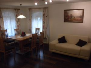 a living room with a table and a couch at Bio-Urlaubshof Dansbach in Spital am Pyhrn