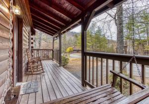 ER74 - Gerrald's Chalet - Great location, Close to all the action! cabin في بيدجن فورج: شرفة من كابينة مع كراسي هزاز عليها