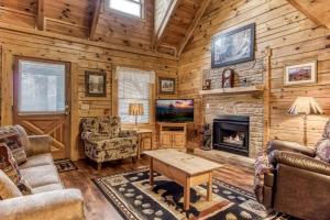 ER74 - Gerrald's Chalet - Great location, Close to all the action! cabin في بيدجن فورج: غرفة معيشة مع مدفأة وتلفزيون