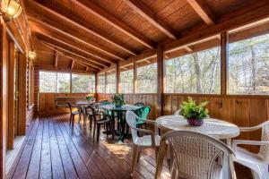 ER92 - Virginia's Villa - Great location! Close to all the action! cabin في بيدجن فورج: شرفة مفتوحة مع طاولات وكراسي ونوافذ