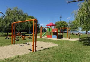 um parque infantil num parque com barras de laranja em Holiday home in Balatonmariafürdo 19534 em Balatonmáriafürdő