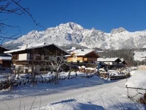 a ski lodge with snow covered mountains in the background at Appartement Harmonie & Balance in Leogang