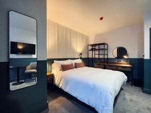 a bedroom with a large white bed and a desk at The Pride of Paddington in London