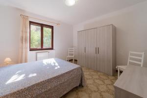 una camera da letto con un letto, un armadio e una finestra di Villa Campo al Pero a Rio Marina
