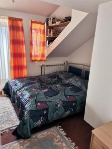 a bedroom with a bed with a comforter at Panorama Apartman in Molvice