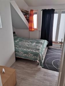 a small bedroom with a bed and a staircase at Panorama Apartman in Molvice