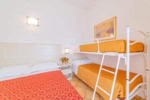 卡托利卡的住宿－Residence Promenade，一间卧室配有两张双层床,铺有红色地毯。