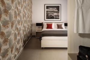 een slaapkamer met een bed en een stenen muur bij Urban Isle Hotel in Il-Gżira