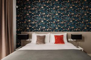 een slaapkamer met een groot bed met bloemenbehang bij Urban Isle Hotel in Il-Gżira