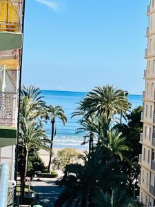 - une vue sur la plage depuis un bâtiment avec des palmiers dans l'établissement Apartamento Mar y Montaña, à Cullera