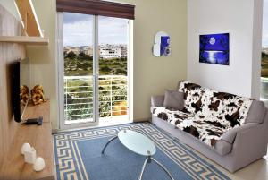 a living room with a couch and a large window at Valley of Honey Apartment in Mosta