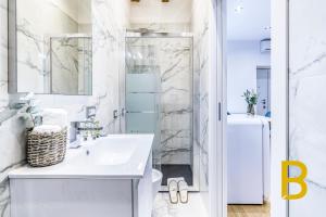 een witte badkamer met een wastafel en een douche bij BePlace Apartments in Gae Aulenti in Milaan
