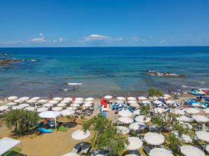 a beach with a bunch of umbrellas and the ocean at Cefalu Resort - Sporting Club in Cefalù
