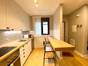 a kitchen with a wooden table and a counter top at Casas La Fuente de Saelices - Alojamiento rural in Saelices el Chico