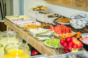un buffet avec de nombreux types d'aliments différents sur une table dans l'établissement Pousada Pedra Rosa, à Florianópolis 16 autres photos