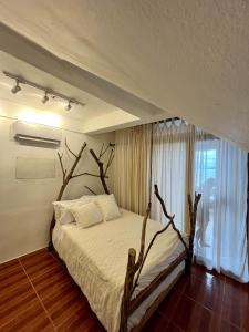 a bedroom with a bed with a tree branch headboard at VILLA NEYRA 