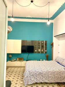 ein Schlafzimmer mit einer blauen Wand und einem Bett in der Unterkunft Funky flat in Palermo