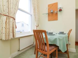 Un comedor con una mesa y una ventana. en Val's Seaview, en Ilfracombe
