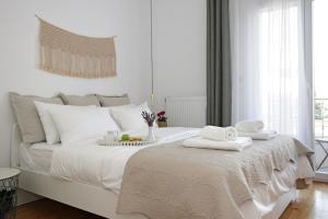 a bedroom with a white bed with towels on it at The 4 Travellers Thessaloniki in Thessaloniki