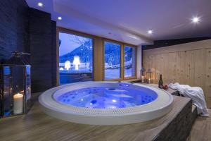 una gran bañera azul en una habitación con ventanas en Residence Aspen en Arabba