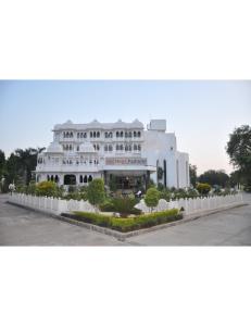 un gran edificio blanco con árboles delante de él en Hotel Padmini, Chittorgarh, en Chittorgarh