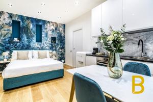 - une chambre avec un lit et une table ornée d'un vase de fleurs dans l'établissement BePlace Apartments in Gae Aulenti, à Milan