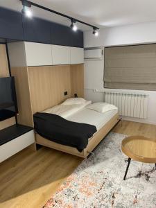 a bedroom with a bed and a table and a tv at Prosper Plaza ApartHotel in Bucharest