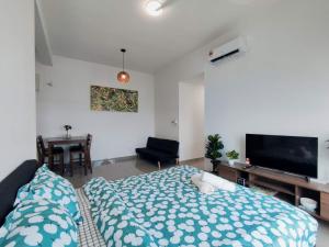 Schlafzimmer mit einem Bett und einem Flachbild-TV in der Unterkunft Balinese Seaview Trevor Amber Suite in Malakka