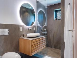 baño con lavabo y 2 espejos en Luksus ferielejlighed med 3 soverum ved stranden i Kerteminde, en Kerteminde