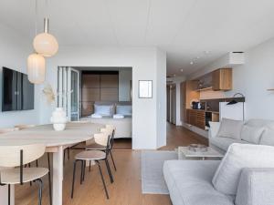uma cozinha e sala de estar com uma mesa e um sofá em Luksus ferielejlighed med 3 soverum ved stranden i Kerteminde em Kerteminde