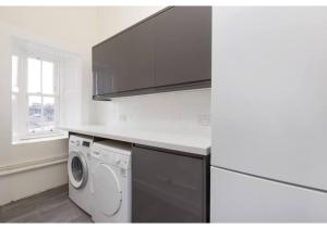 una cucina con lavatrice e forno a microonde di Spacious 3-bed Flat with Castle Views a Edimburgo