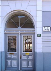 Una puerta azul con dos ventanas en un edificio en Das alte Zinshaus, en Knittelfeld