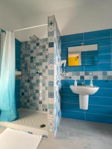 La salle de bains bleue est pourvue d'un lavabo et d'une douche. dans l'établissement B&B D'Aponte Home, à Volla